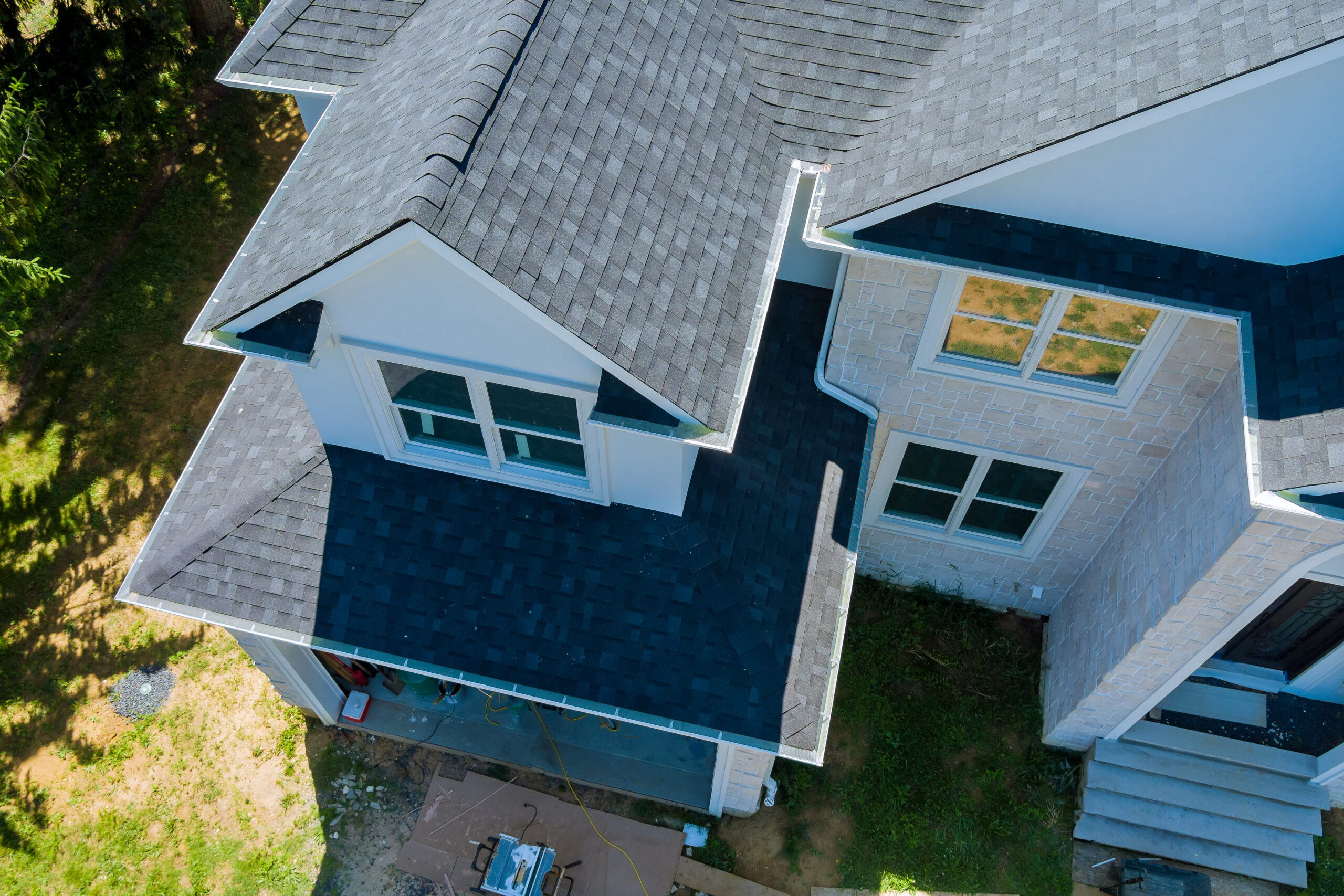 rooftop new home constructed showing asphalt shingles multiple roof lines with aerial view scaled